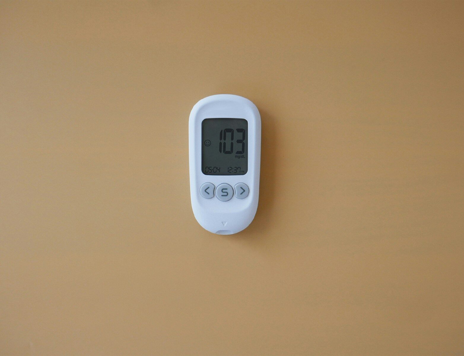 a digital thermometer on a tan wall